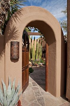 an entrance to a home with cactus and succulents in the foreground