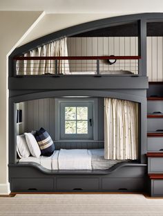 a bunk bed in the corner of a room with stairs leading up to it's second floor