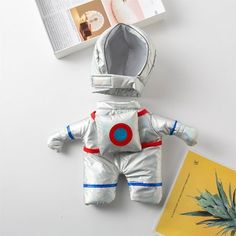 an astronaut doll next to a book and pineapple