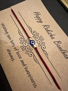 a red string bracelet with an evil eye on it sitting on top of a card