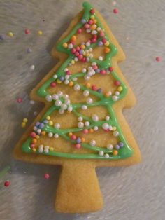 a decorated christmas tree cookie sitting on top of a table