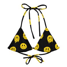 Hit the festival grounds in standout style with the Trippie Bikini Top. Splashed with a vibrant yellow and black smiley design, this top is all about comfort as you enjoy the music and vibes. •Its eco-friendly recycled fabric and UPF 50+ protection ensure you're all set for those sun-soaked festival days. • Adjustable Comfort: Crafted with flexible straps, find your perfect fit and style it. • Soft & Stretchy: The material moves with you so that you can dance and groove without a care. • Inclusi Playful Black Swimwear For The Beach, Playful Black Swimwear For Beach Season, Black Graphic Print Swimwear For Beach, Trendy Graphic Print Swimwear, Fun Graphic Print Swimwear For The Beach, Fun Graphic Print Swimwear For Beach, Summer Beach Rave Tops, Trendy Summer Swimwear For Music Festival, Trendy Swimwear For Summer Music Festival