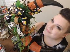 a woman is holding a fake antlers and pumpkins on her head while posing for the camera