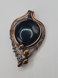 A wire wrapped pendant featuring a round Onyx cabochon. Woven design on the back, and copper beads and swirls on the front. Wire Wrapped Stone Jewelry, Wire Wrap Jewelry Designs, Onyx Pendant, Wire Wrapping Stones, Diy Wire Jewelry, Wrap Jewelry, Wire Necklace, Handmade Wire Wrapped, Necklace Simple