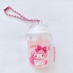 a pink hello kitty sippy cup with a chain attached to the top and lid