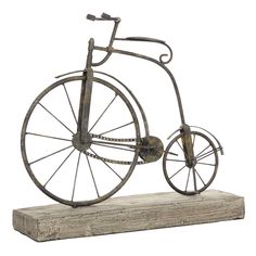 an old fashioned bicycle is sitting on top of a wooden block and it's made out of metal