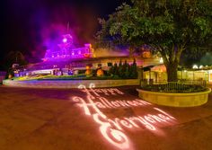 the entrance to disneyland's halloween horror garden is lit up with purple and red lights