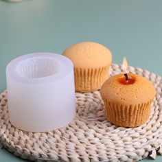 two cupcakes on a wicker plate with a candle in the middle one