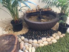 a water fountain surrounded by rocks and plants