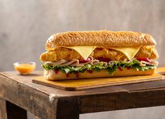 a chicken sandwich sitting on top of a wooden table