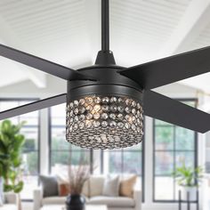 a living room with a ceiling fan that has lights hanging from it's blades