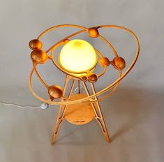 a wooden table lamp with an orange light on it's base and eight balls in the center