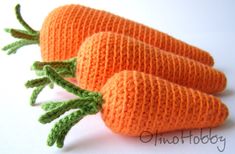 three knit carrots sitting next to each other