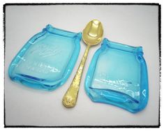 two blue glass dishes and a gold spoon