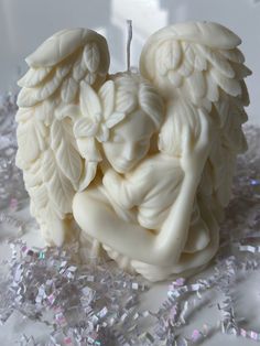 a white candle with an angel design on it