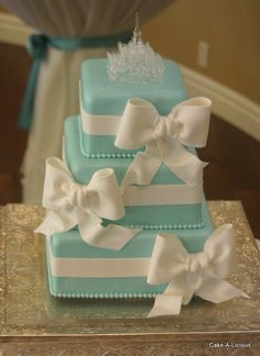 two tiered cake with white bows and a tiara on top