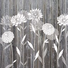 white flowers are on the wooden fence