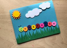 a card with the word thank you written in colorful letters on grass and sun above it