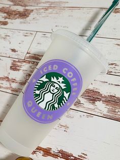 a starbucks cup sitting on top of a wooden table