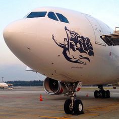 an airplane is parked on the tarmac with another plane in the back ground behind it