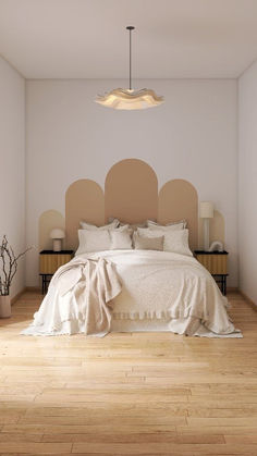 a large bed sitting on top of a hard wood floor next to a wall mounted light