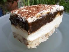 a piece of cake sitting on top of a plate covered in chocolate and white frosting