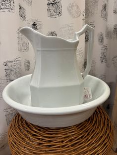 a white pitcher sitting on top of a wicker basket