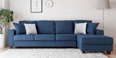 a living room with a blue couch and white rug