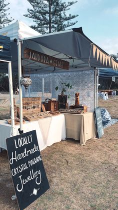 there is a sign that says local handmade crystals and jewelry on display at the market