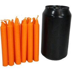 several orange candles are next to a black can