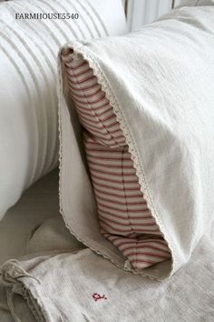 a white pillow with a red stripe on it and some pillows in front of it