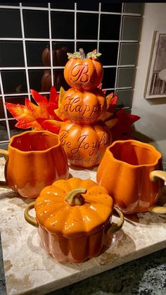 four pumpkin shaped dishes sitting on top of a counter