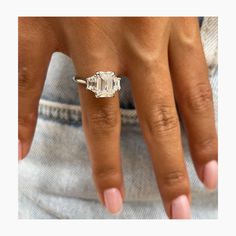 a woman's hand with an engagement ring on it