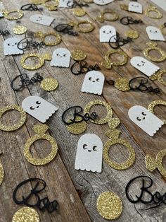 halloween decorations are laid out on top of a wooden table with black and gold glitter