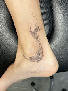 a woman's foot with a fish tattoo on the side of her leg,