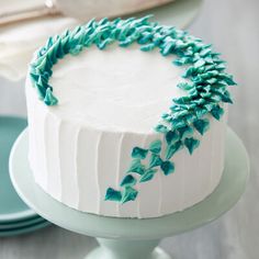 a cake with white frosting and green sprinkles sitting on a plate