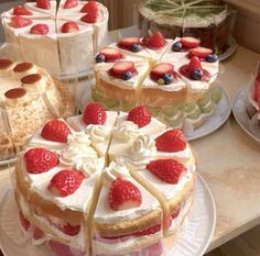 there are many cakes on the table with strawberries