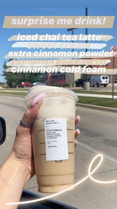 a woman holding up a cup of coffee in her hand with the caption surprise me drink iced tea latte extra cinnamon flavor