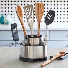 kitchen utensils in a stainless steel container on a counter