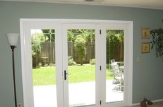 a living room with sliding glass doors leading to a patio and back yard in the background