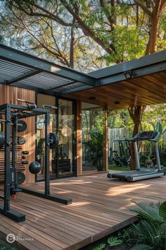 an outdoor gym area with exercise equipment and trees in the backgrouds, surrounded by greenery