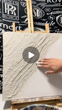 someone is painting on the easel with their hands and thumbnails in front of it