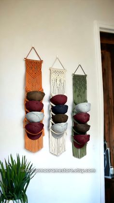 three macrame wall hangings with different colors and designs on them in a living room