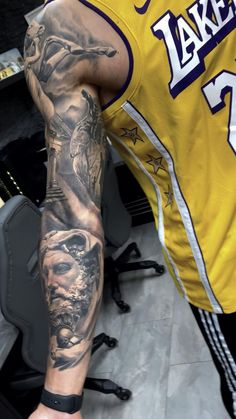 a man with a tattoo on his arm in a yellow jersey is holding a basketball