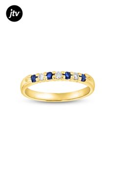 a yellow gold ring with blue and white stones on the side, in front of a white