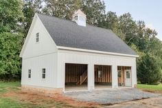 a white barn with an open garage door