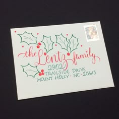 a christmas postcard with holly and berries on it, the letter family is printed in red ink