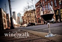 a glass of wine sitting on the side of a road next to a brick building