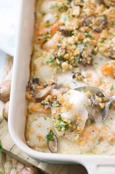 a casserole dish with shrimp, mushrooms and carrots in it is ready to be eaten