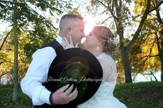 a bride and groom kissing in front of trees with the sun shining through their eyes